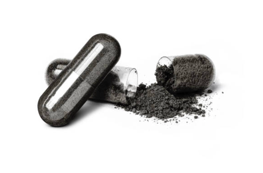 Charcoal tablet and powder on a white background