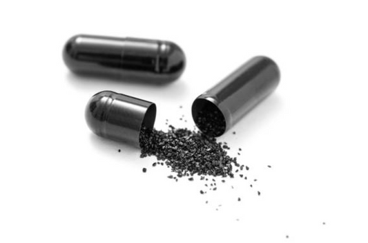 Three black capsules with one open, revealing black powder on a white background