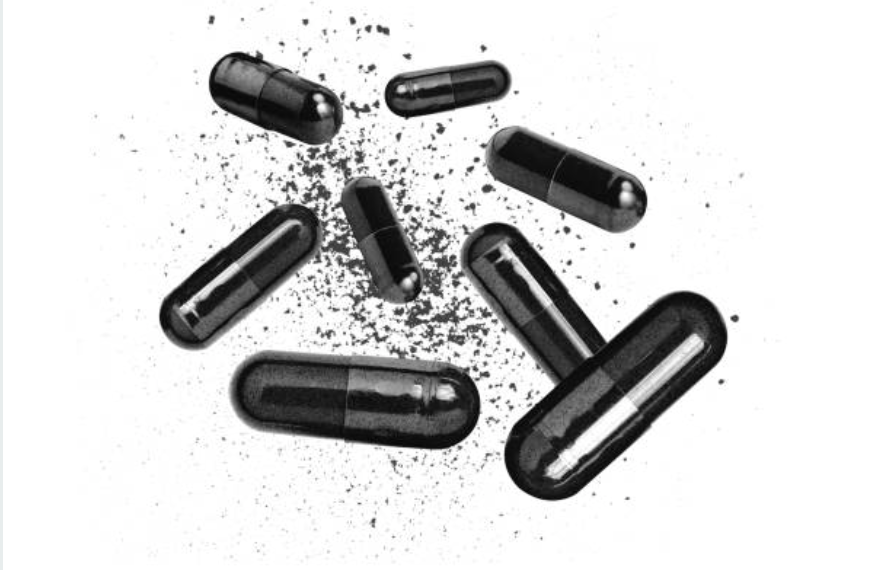 Black capsules scattered on a white background